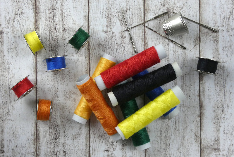 Nähmaschine Test Buntes Nähgarn mit Nadeln und Fingerhut